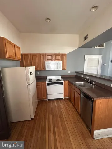 a kitchen with granite countertop a sink and a stove top oven