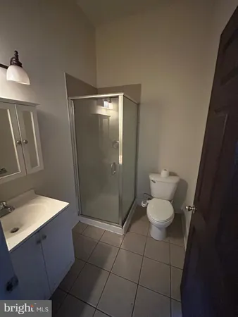 a bathroom with a granite countertop sink a toilet a mirror and vanity