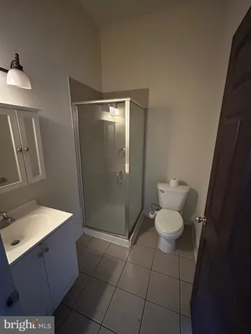 a bathroom with a granite countertop sink a toilet a mirror and vanity