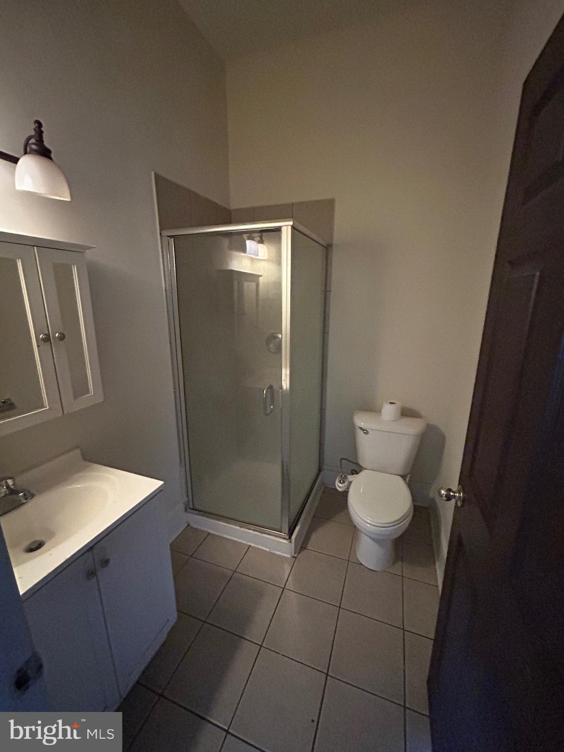 319 West Mulberry Street, Unit 2 Baltimore, MD 21201 - Photo 5 of 7 a bathroom with a granite countertop sink a toilet a mirror and vanity