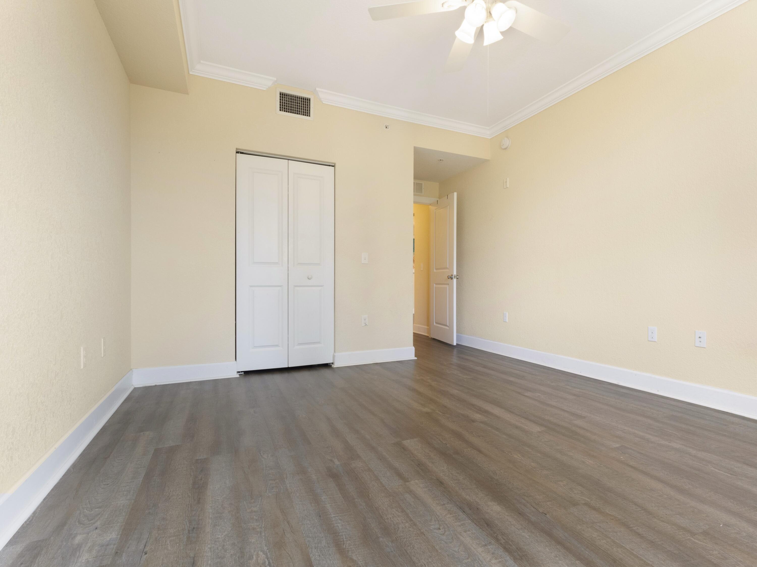 1690 Renaissance Commons Boulevard, Unit 1412 Boynton Beach, FL 33426 - Photo 15 of 49 a view of an empty room with wooden floor and a ceiling fan