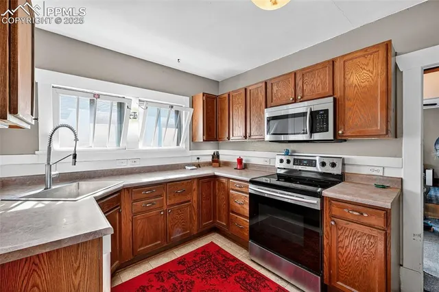 a kitchen with stainless steel appliances granite countertop a stove sink microwave and cabinets