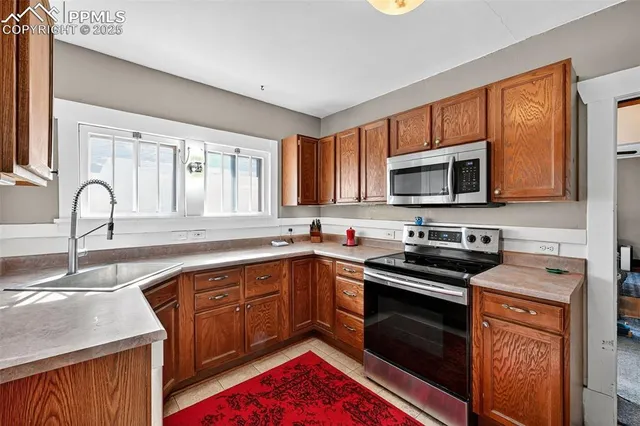 a kitchen with stainless steel appliances granite countertop a stove sink microwave and cabinets