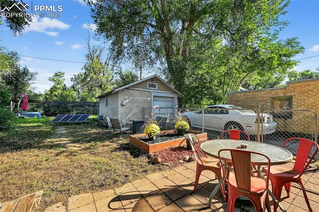 a backyard of a house with table and chairs