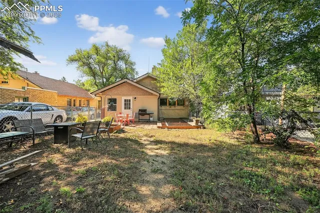 a view of a house with backyard and sitting area