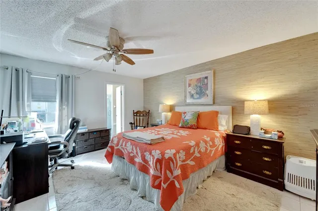 a bedroom with a bed a flat screen tv and a book shelf