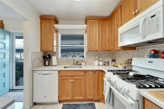 a kitchen with cabinets appliances a sink and a window