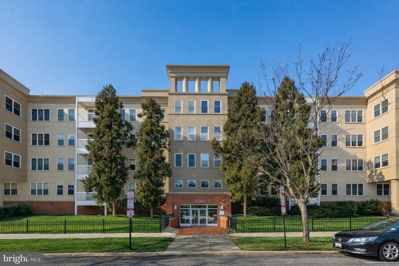 a car parked in front of a brick building next to a yard