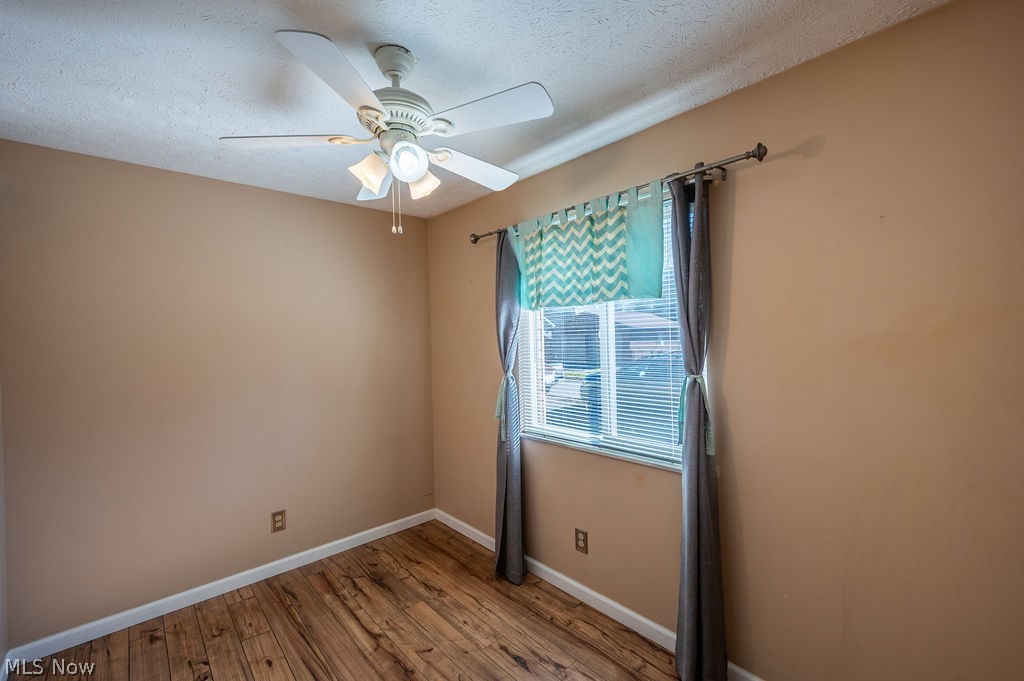 3601 River Road Vienna, WV 26105 - Photo 21 of 40 Unfurnished room featuring light wood finished floors, a ceiling fan, and a textured ceiling