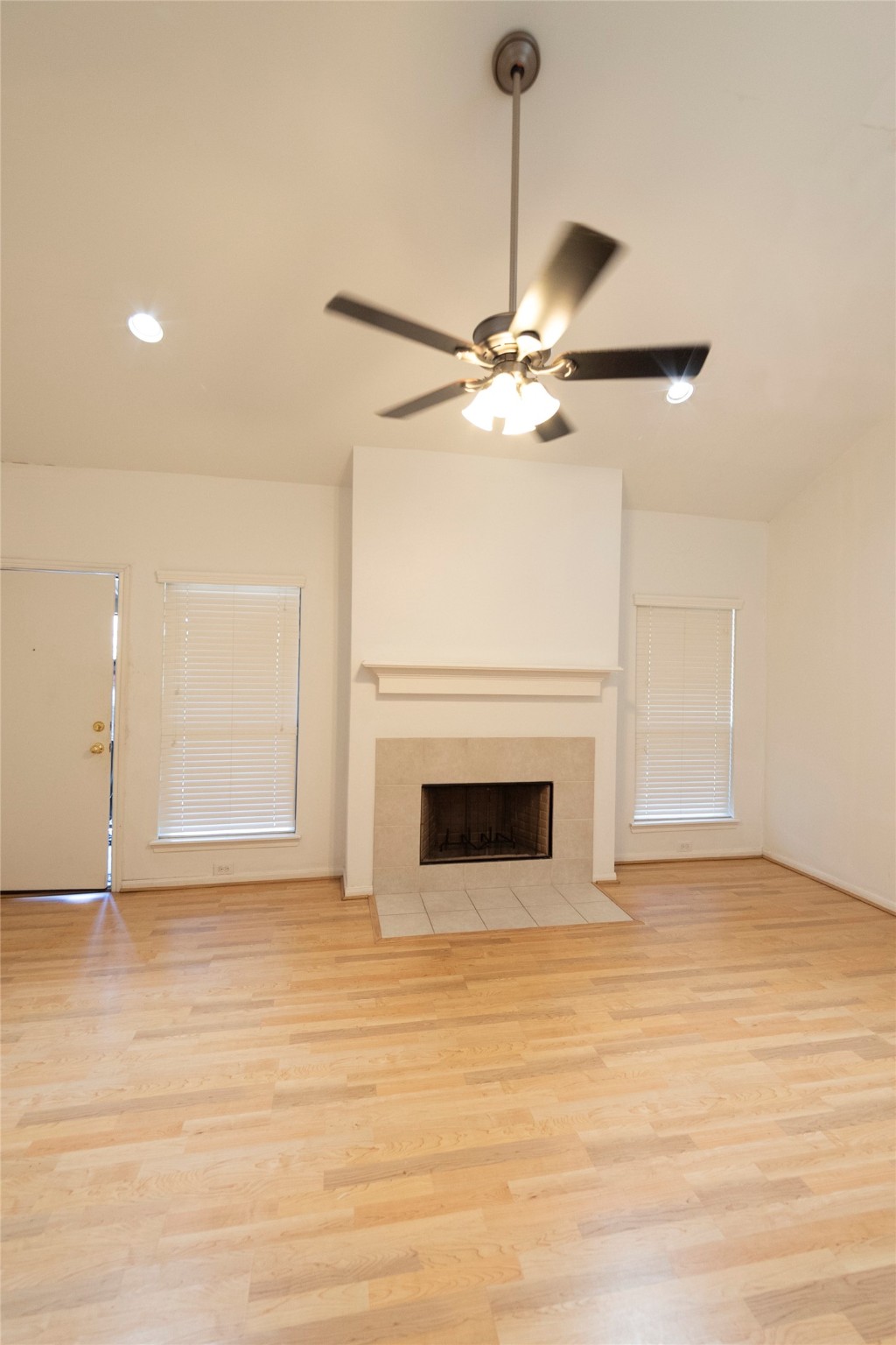 1100 Augusta Drive, Unit 76 Houston, TX 77057 - Photo 4 of 12 a view of a livingroom with a ceiling fan a fireplace and wooden floor