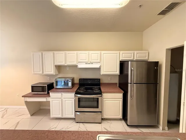 a kitchen with a refrigerator stove and microwave