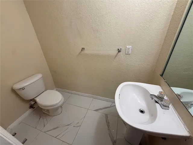 a view of a hallway with wooden floor and a ceiling fan