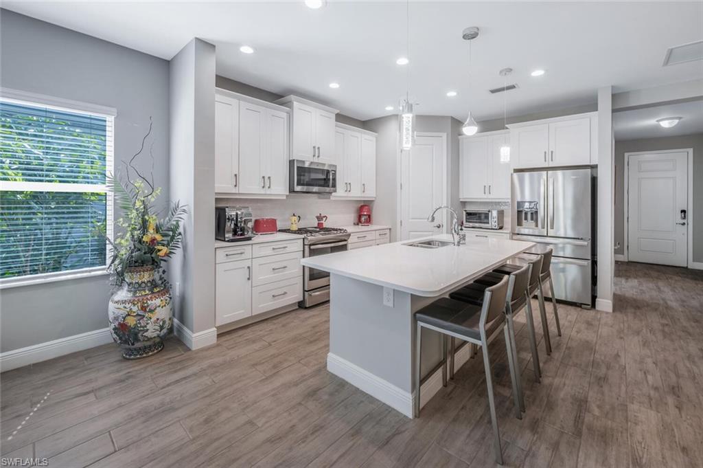 2167 Marquesa Circle Naples, FL 34112 - Photo 2 of 21 a kitchen with stainless steel appliances a sink a stove a refrigerator cabinets and wooden floor