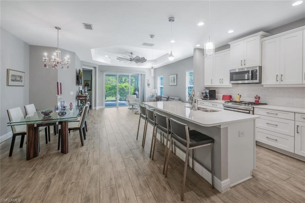 2167 Marquesa Circle Naples, FL 34112 - Photo 7 of 21 a kitchen with kitchen island granite countertop a sink a counter space and stainless steel appliances