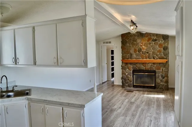 a kitchen with white cabinets and a fireplace