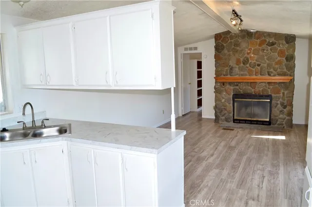 a kitchen with granite countertop a stove oven and a white cabinets