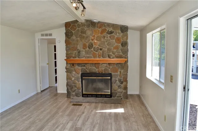 a view of a livingroom with a fireplace and window