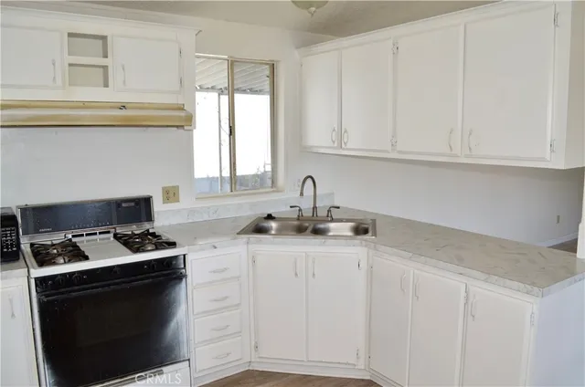 a kitchen with granite countertop white cabinets and a stove