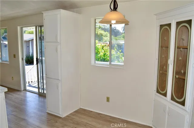 a view of a hallway with wooden floor and a chandelier