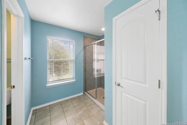 a spacious bathroom with a double vanity sink a mirror and a shower