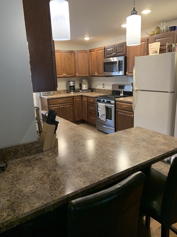 36 Boston Road North Billerica, MA 01862 - Photo 4 of 17 a kitchen with stainless steel appliances granite countertop a sink a stove and a refrigerator