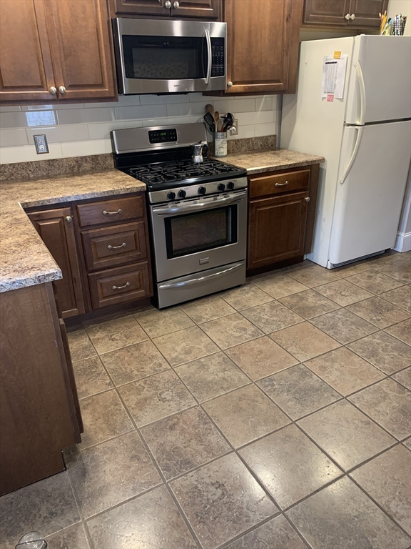 36 Boston Road North Billerica, MA 01862 - Photo 5 of 17 a kitchen with granite countertop a stove a sink and a refrigerator