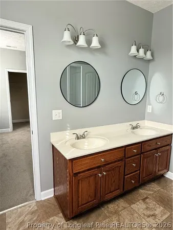 an empty room with a chandelier fan and windows