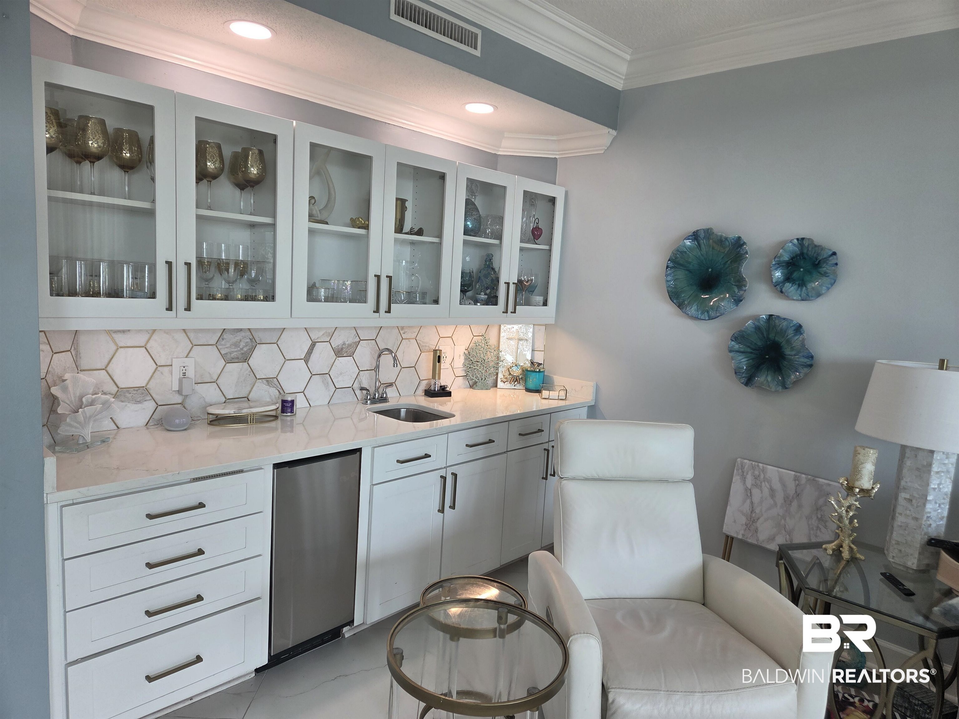27580 Canal Road, Unit 1210 Orange Beach, AL 36561 - Photo 13 of 28 Bar with light stone countertops, glass insert cabinets, backsplash, ornamental molding, and white cabinets