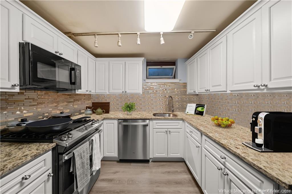 a kitchen with stainless steel appliances granite countertop a sink stove microwave and cabinets