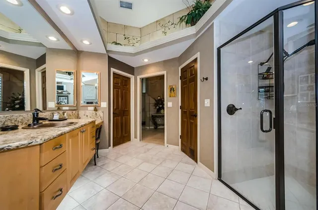 a bathroom with a granite countertop sink mirror and shower