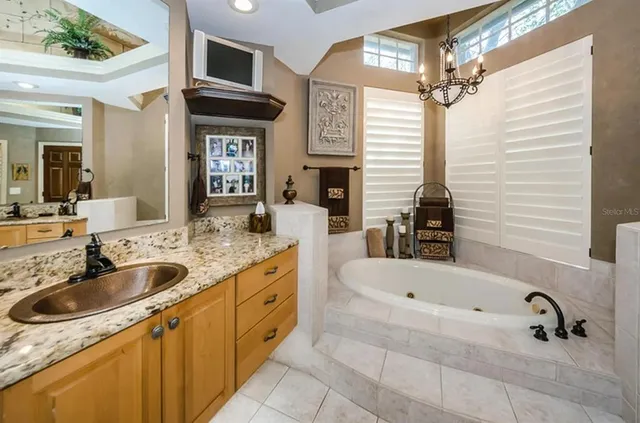 a bathroom with a granite countertop sink and a bathtub