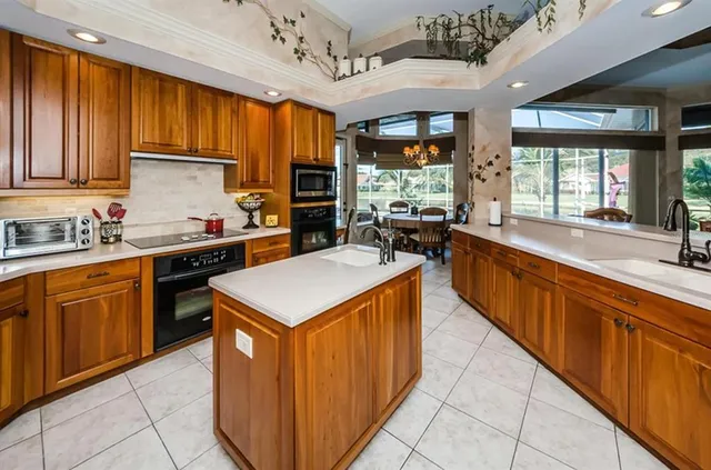 a kitchen with stainless steel appliances granite countertop sink stove top oven and cabinets