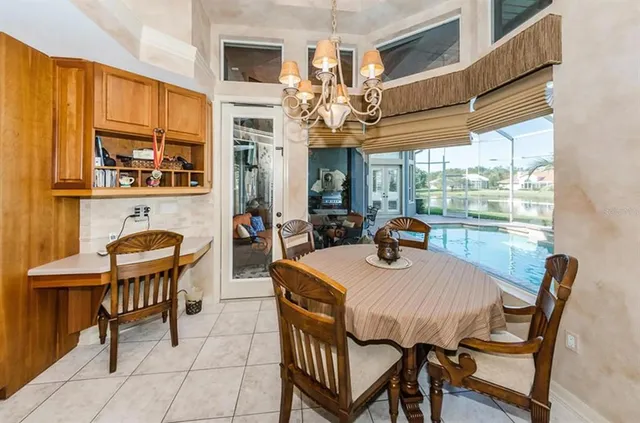 a dining room with furniture a chandelier and window