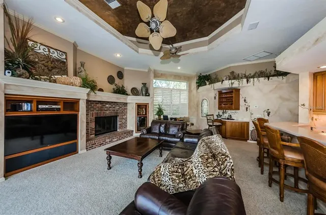 a living room with furniture a fireplace and a chandelier