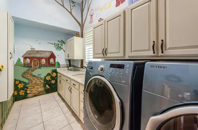 a utility room with stainless steel appliances lots of clutter and washer