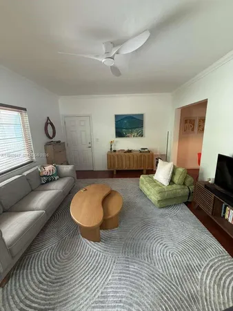 a living room with furniture a rug and a flat screen tv