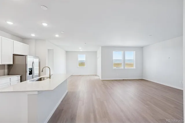 a kitchen with granite countertop a sink cabinets and wooden floor