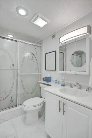 a bathroom with a toilet a sink a mirror and vanity