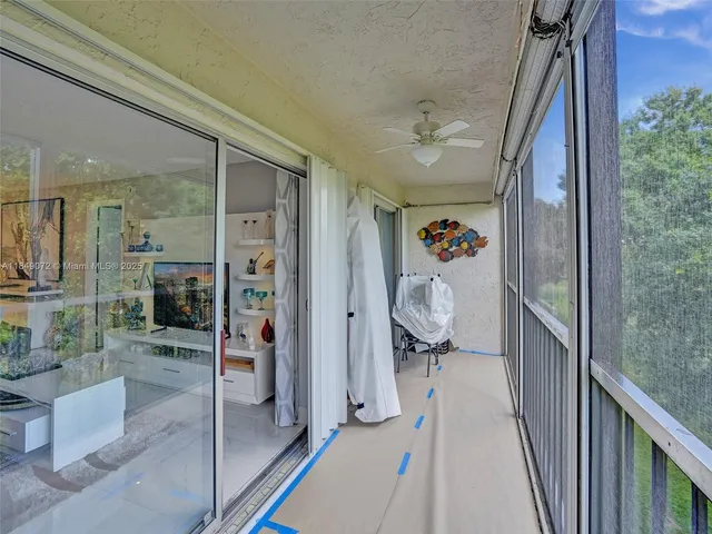 a view of a hallway with wooden floor and windows