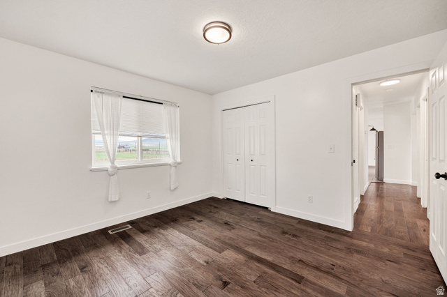 365 South Center Street Fielding, UT 84311 - Photo 17 of 41 Unfurnished bedroom with dark wood-style flooring and a closet
