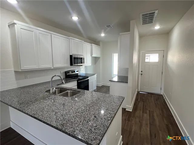 a kitchen that has a sink and cabinets