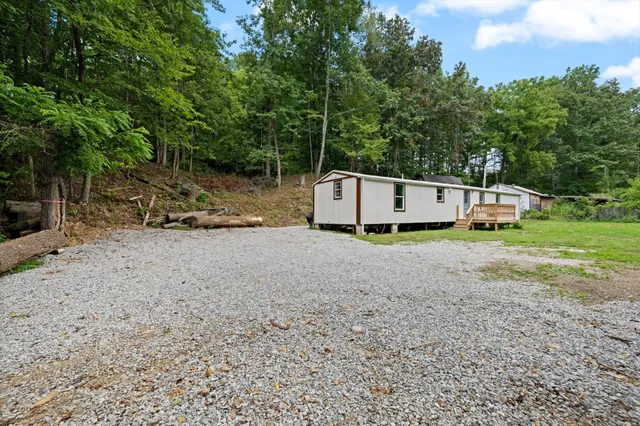a view of a barn in a yard with large trees