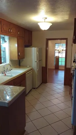 a kitchen with stainless steel appliances granite countertop a sink and a refrigerator