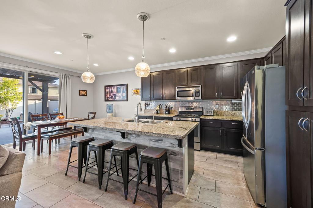 396 Edgewood Drive Fillmore, CA 93015 - Photo 8 of 37 a kitchen with stainless steel appliances granite countertop a stove a refrigerator a kitchen island a sink cabinets and a refrigerator