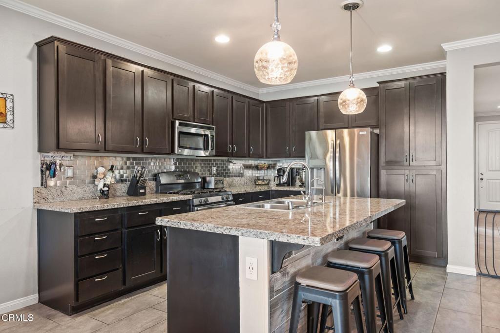 396 Edgewood Drive Fillmore, CA 93015 - Photo 9 of 37 a kitchen with kitchen island granite countertop stainless steel appliances and wooden cabinets