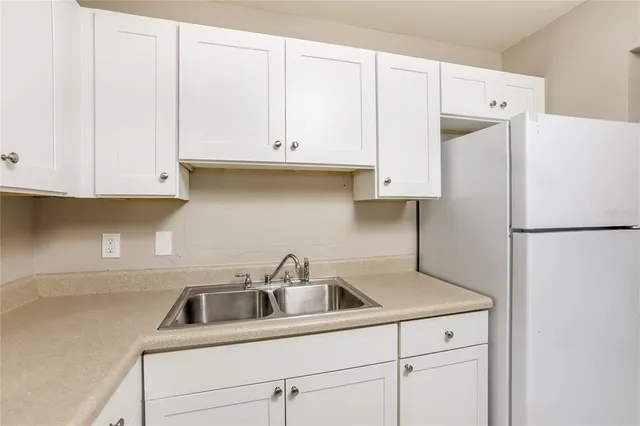 a kitchen with a sink a refrigerator and cabinets