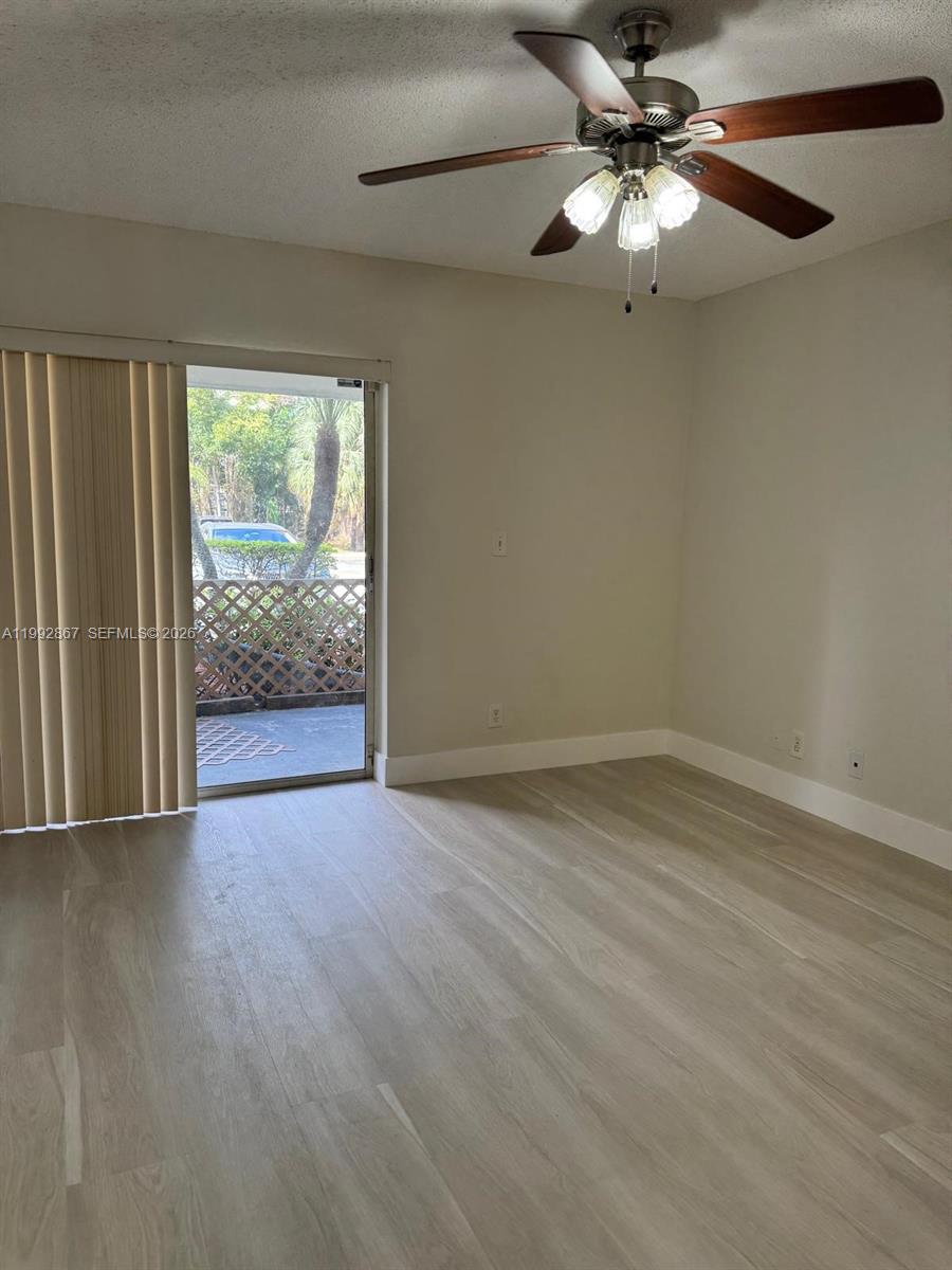 5760 Rock Island Road, Unit 304 Tamarac, FL 33319 - Photo 11 of 40 wooden floor in an empty room with a window
