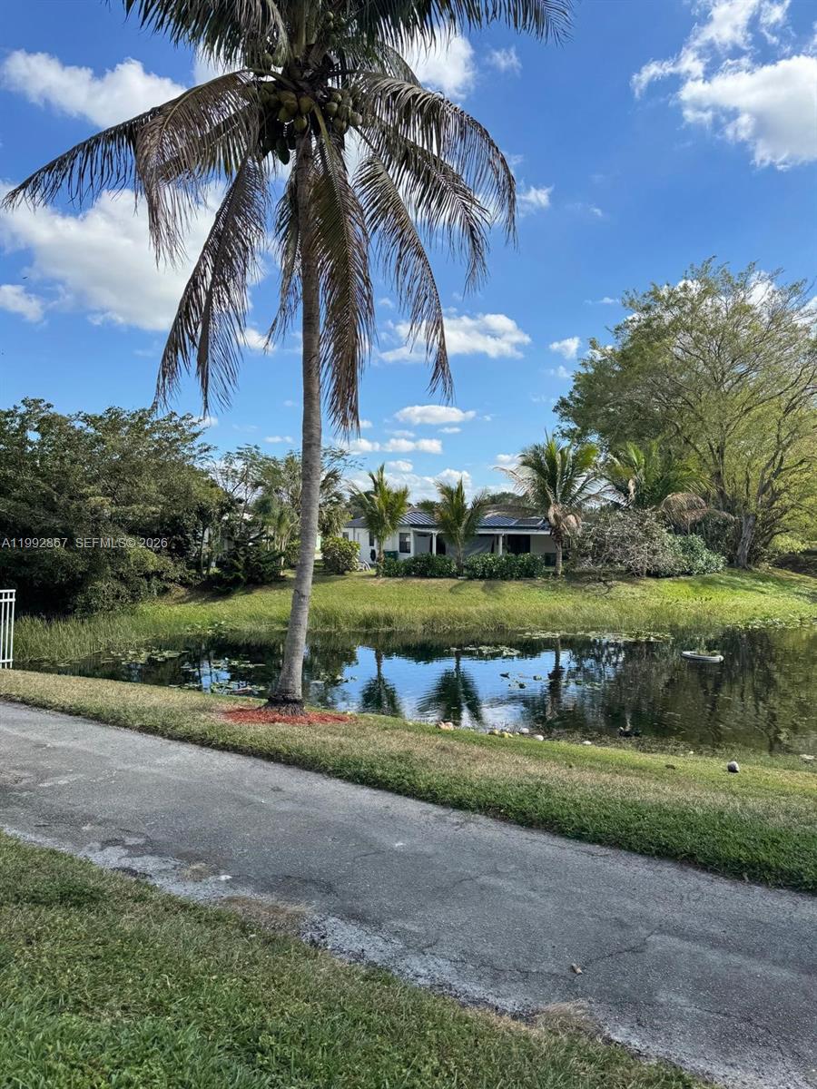 5760 Rock Island Road, Unit 304 Tamarac, FL 33319 - Photo 17 of 40 front view of a house with a yard and potted plants