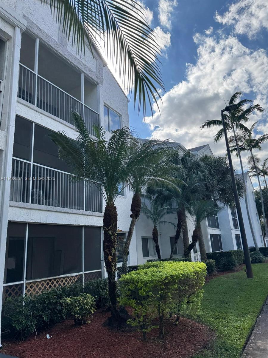 5760 Rock Island Road, Unit 304 Tamarac, FL 33319 - Photo 18 of 40 a front view of a house with a yard