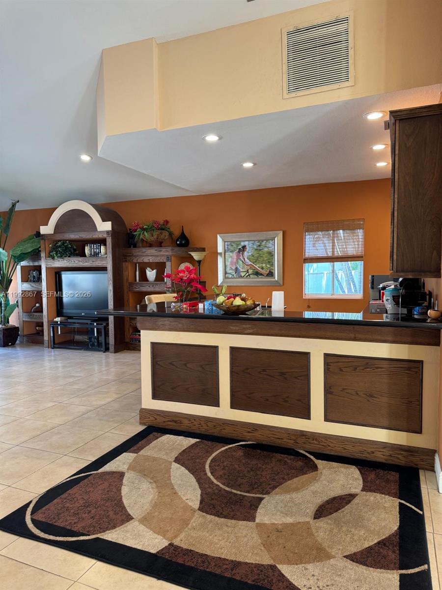 5760 Rock Island Road, Unit 304 Tamarac, FL 33319 - Photo 22 of 40 a living room with stainless steel appliances kitchen view and a fireplace